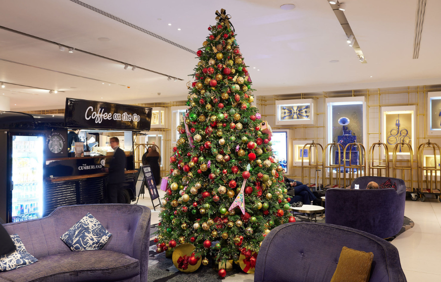 Christmas tree in hotel lobby with festive decorations and seating area
