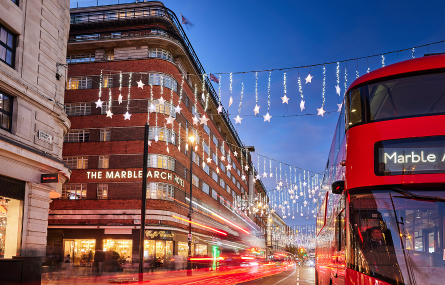 London street with Christmas lights, a red double-decker bus, and The Marble Arch hotel